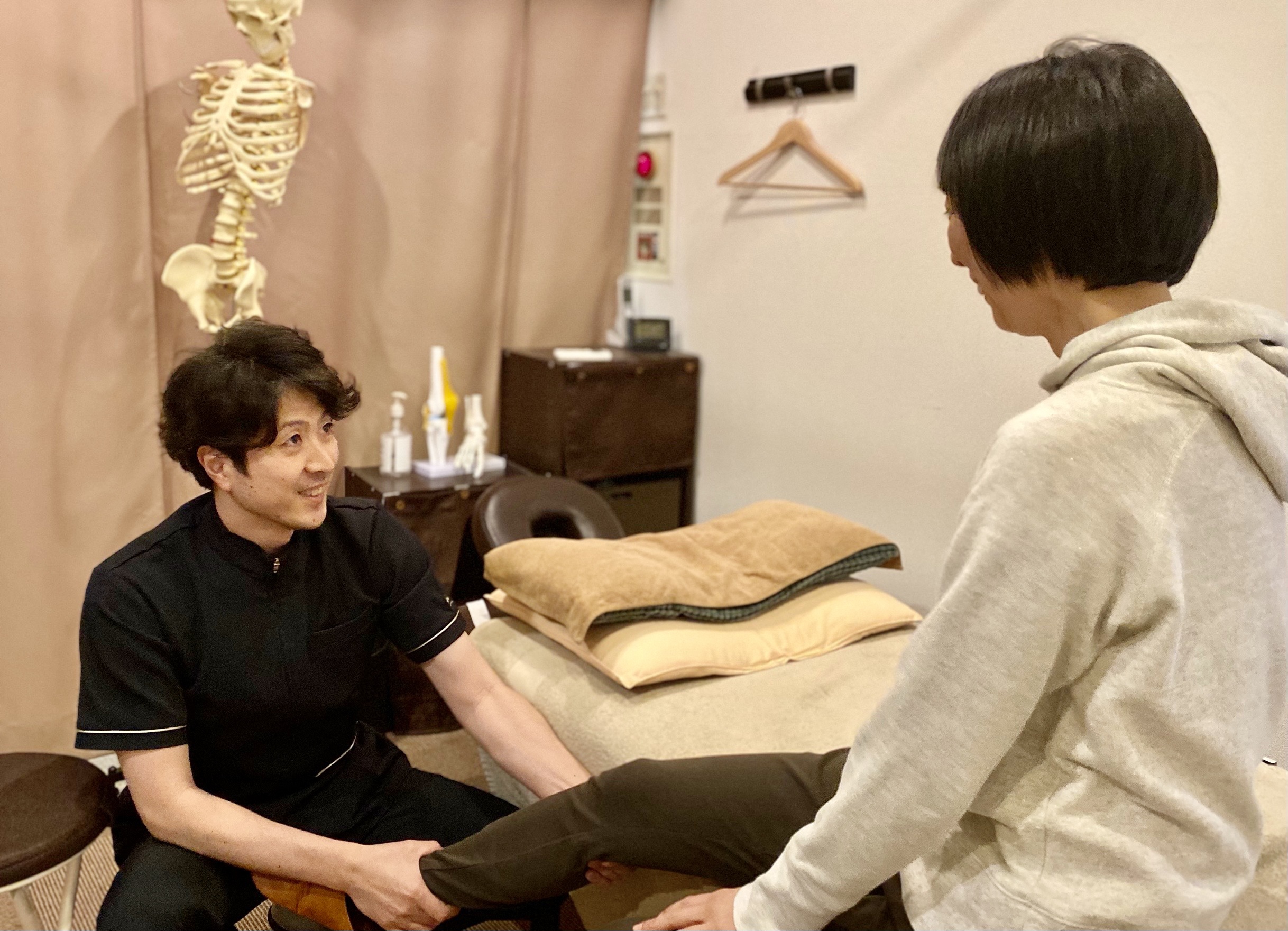 患者さんの足に触れて身体の状態を確認している様子